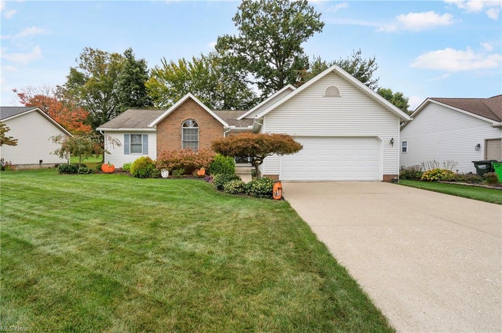 Ranch-style home featuring a front yard and a gara