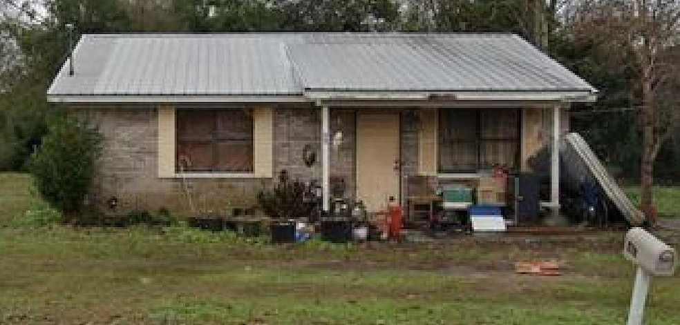 Bungalow-style home featuring metal roof and a front lawn