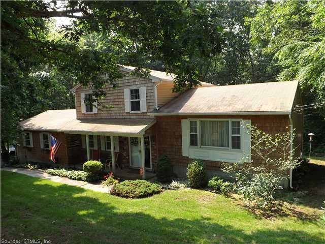 Exterior Front. Surrounded by mature trees, shrubs