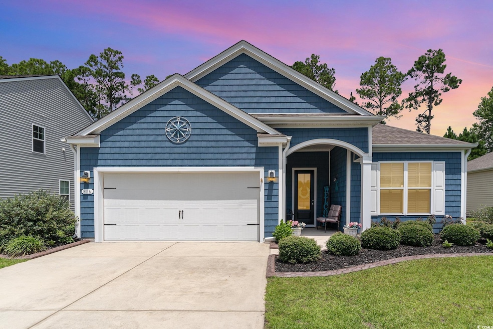 View of front of home with a garage and a yard