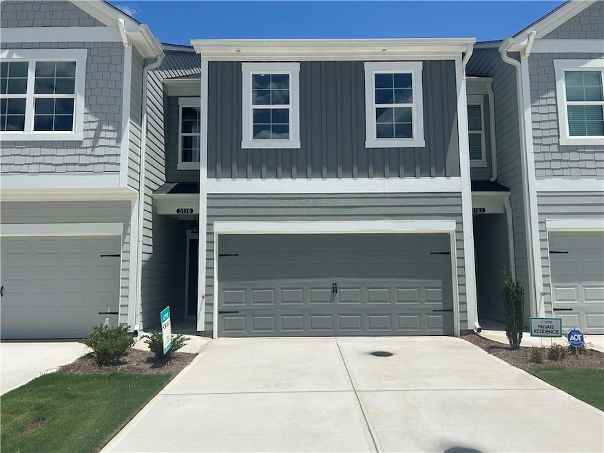 View of front of home featuring concrete driveway and an attached garage