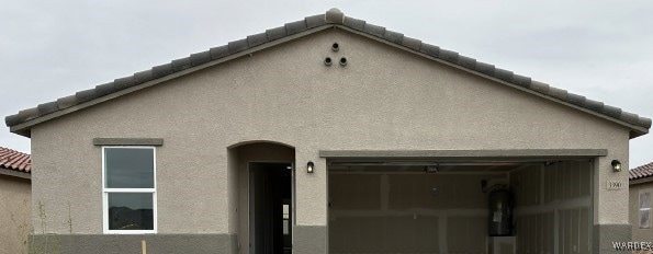 View of front of house with stucco siding, a tile