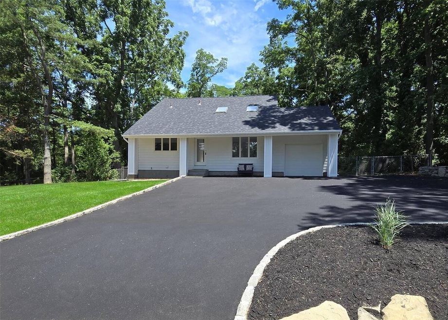 View of front of house featuring an attached garage, a porch, and asphalt driveway