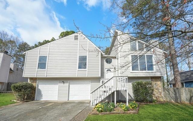 View of front of home featuring a garage and concrete driveway