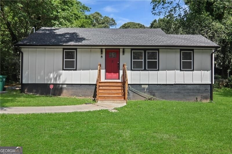 View of front of property with entry steps, a shingled roof, board and batten siding, a front lawn, and crawl space