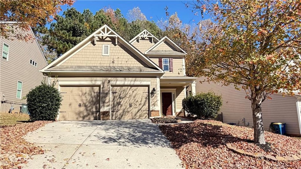 Craftsman-style house with concrete driveway, covered porch, and an attached garage