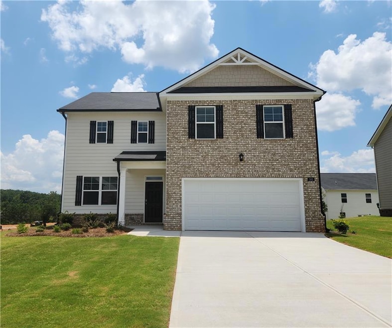 Craftsman-style home with brick siding, a front yard, concrete driveway, and an attached garage