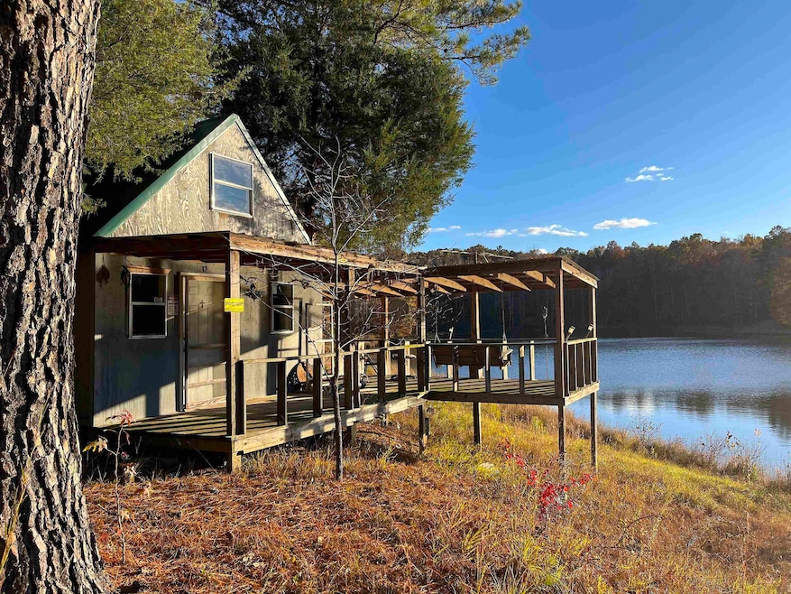 Dock area featuring a deck with water view and a view of trees