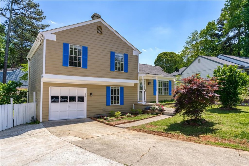 View of front of house with a front lawn and a gar