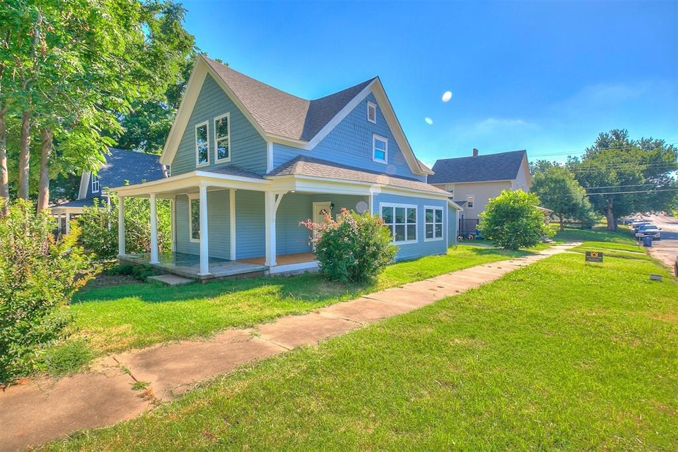 View of front of home with a front yard and a porc