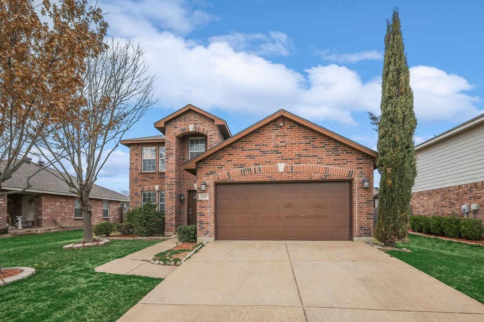 View of property with a garage and a front lawn