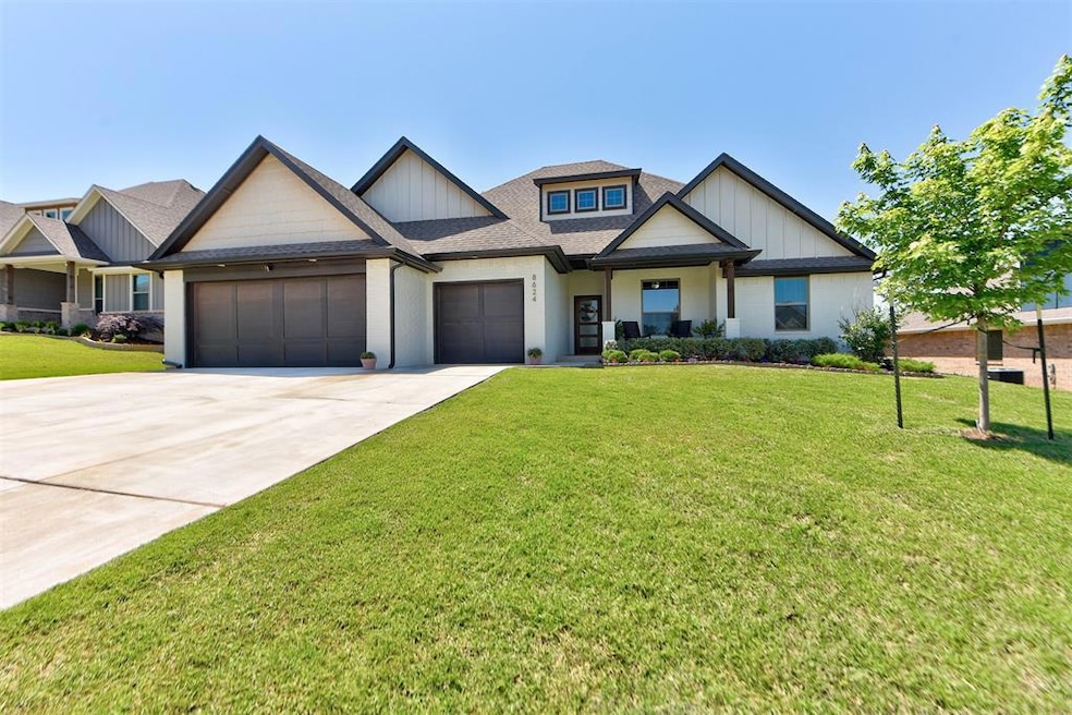 Craftsman-style house with an attached garage, driveway, a front yard, and a shingled roof