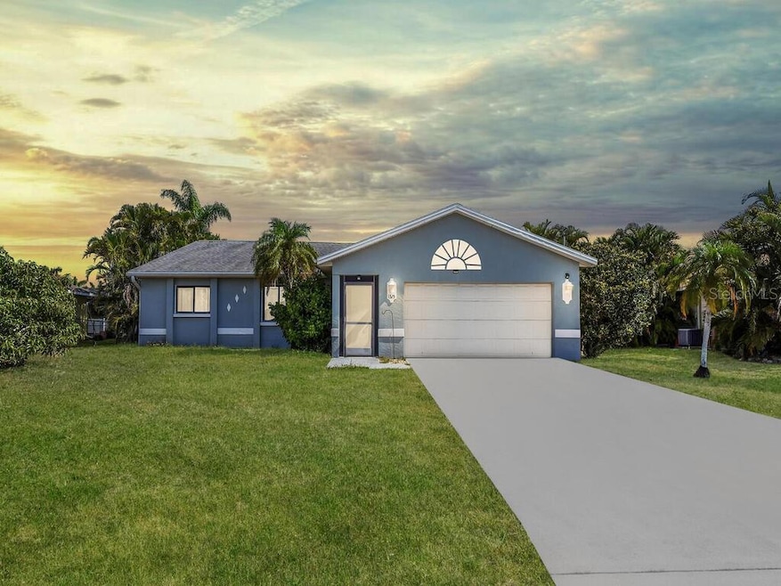 Charming front exterior with tropical landscaping, and a spacious driveway with a two-car garage.