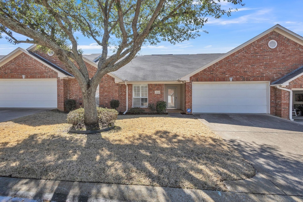 Ranch-style house featuring concrete driveway, bri