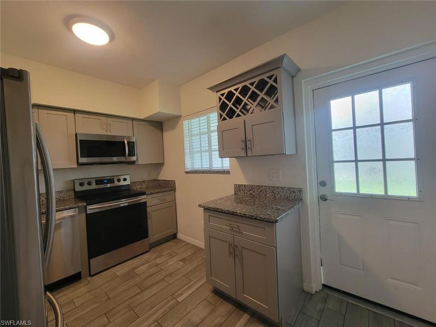 Kitchen featuring appliances with stainless steel finishes, gray cabinetry, plenty of natural light, and wood finish floors