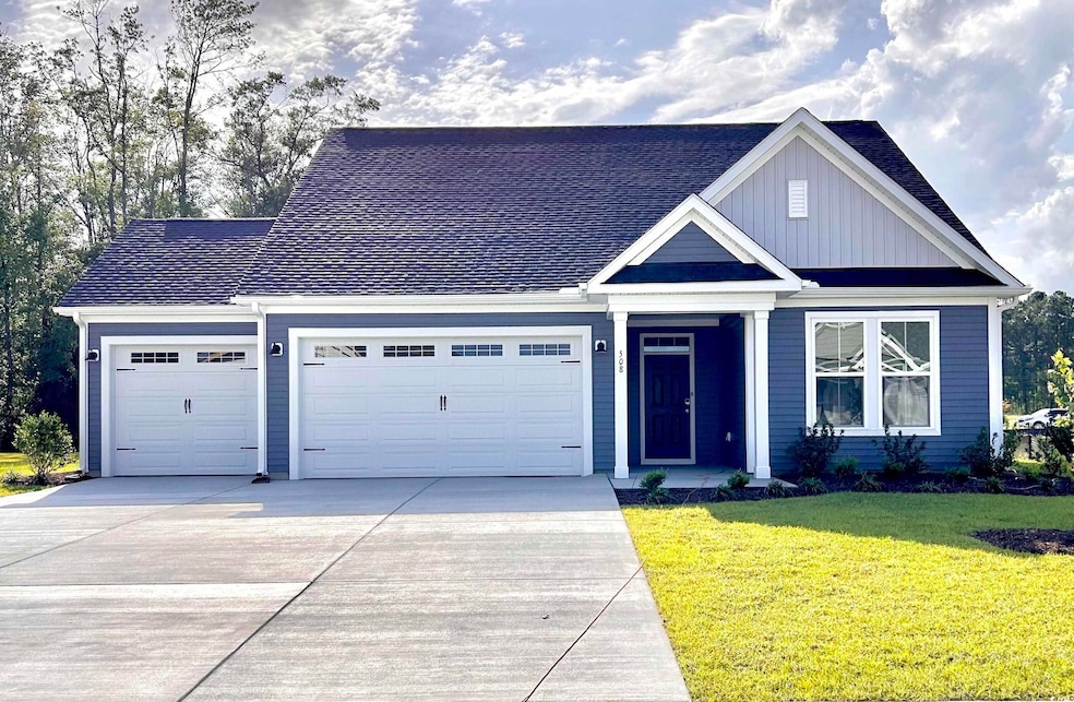 View of front of property with a garage, concrete driveway, board and batten siding, a front yard, and roof with shingles