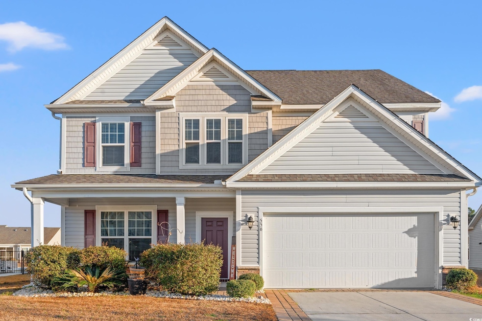 View of front of home with a garage and covered po