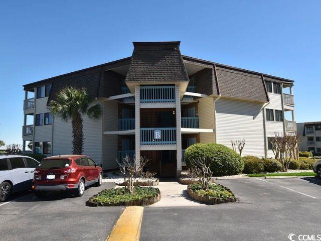 View of property featuring uncovered parking