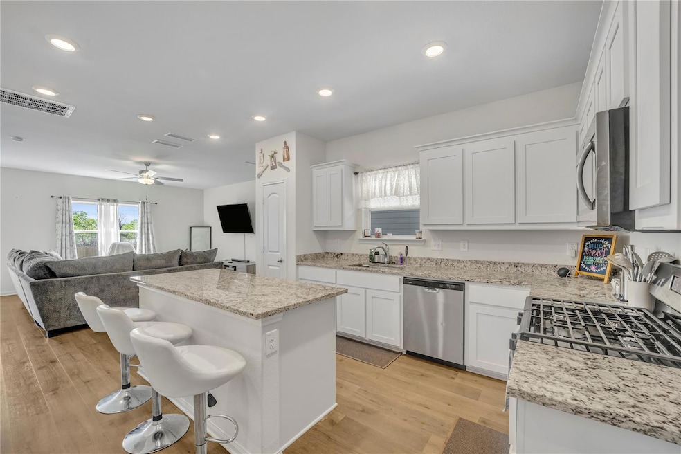 Kitchen featuring visible vents, white cabinets, a