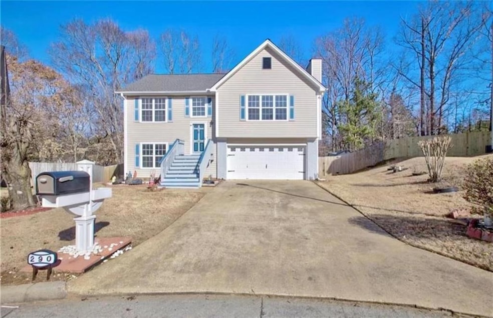 View of front of house featuring an attached garage, a chimney, and concrete driveway