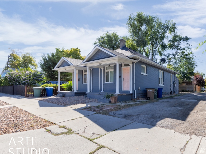 Bungalow-style house featuring covered porch, a chimney, and driveway