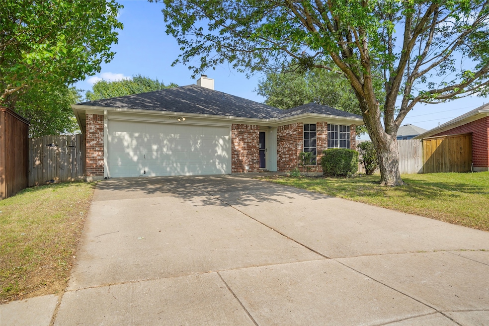 Single story home featuring concrete driveway, a chimney, an attached garage, and brick siding