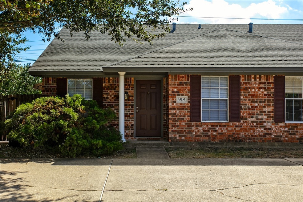 Ranch-style home with a shingled roof and brick siding