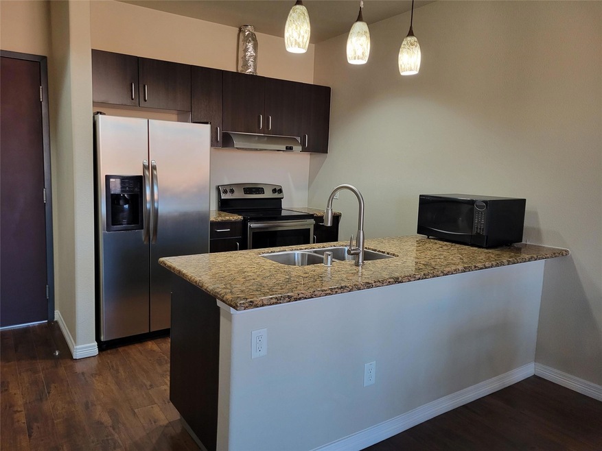 Kitchen featuring stainless steel appliances, dark