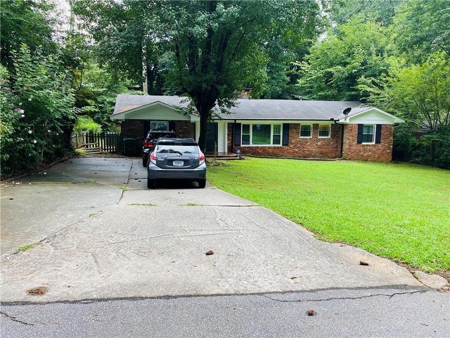 Single story home with a front lawn, fence, brick 