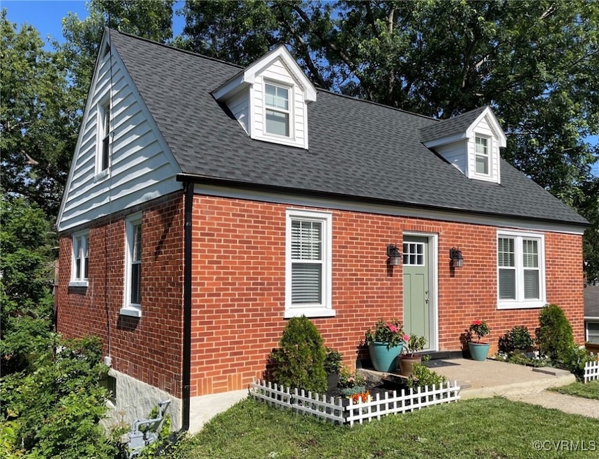 New england style home with brick siding and roof