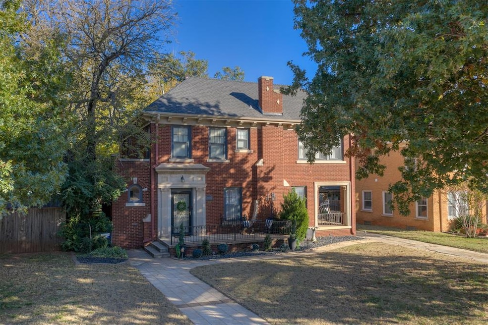View of front of home featuring a chimney and brick siding