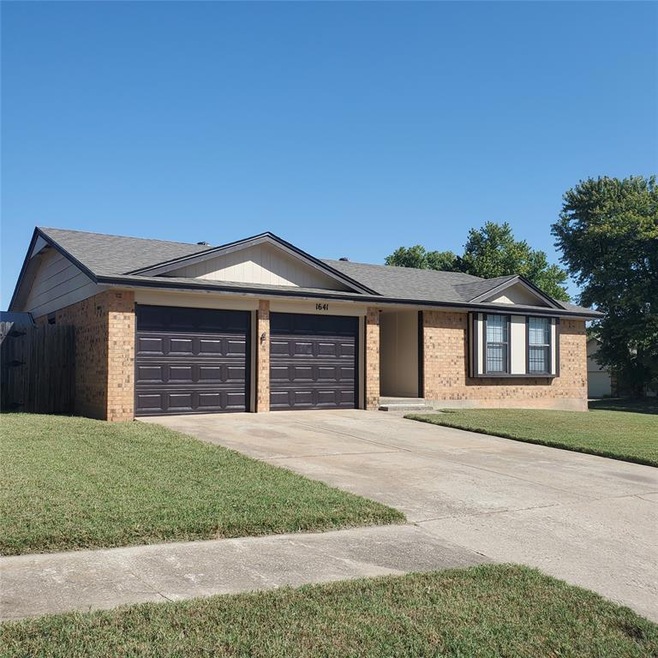 Ranch-style home with a garage and a front lawn