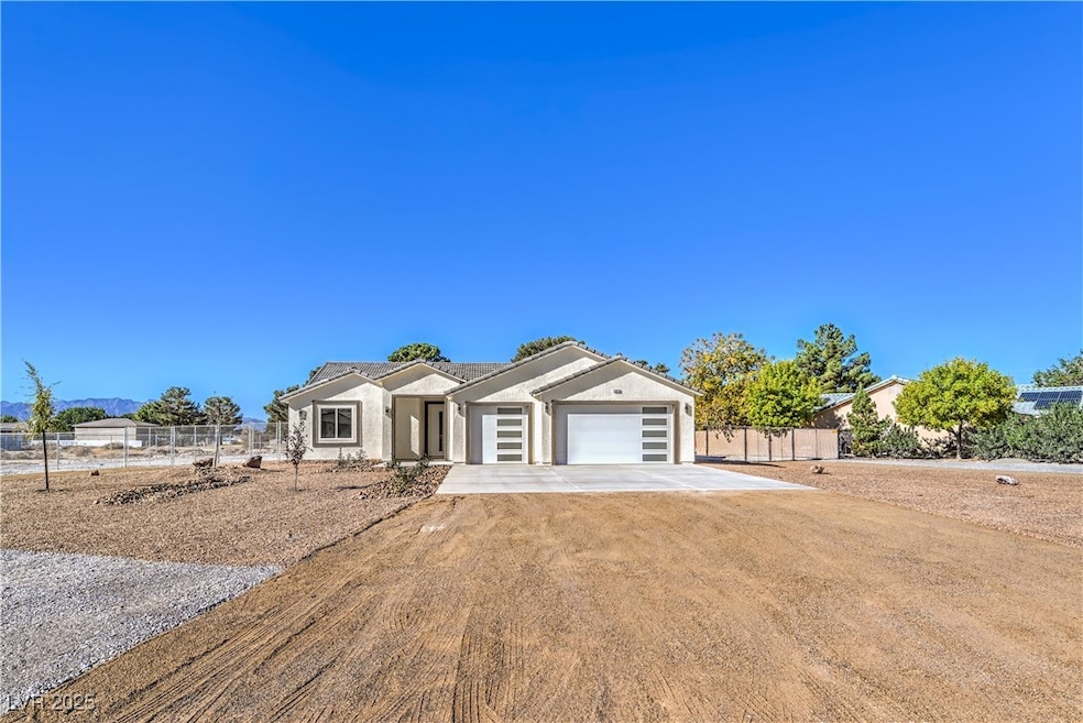 Ranch-style house with driveway, an attached garage, and stucco siding