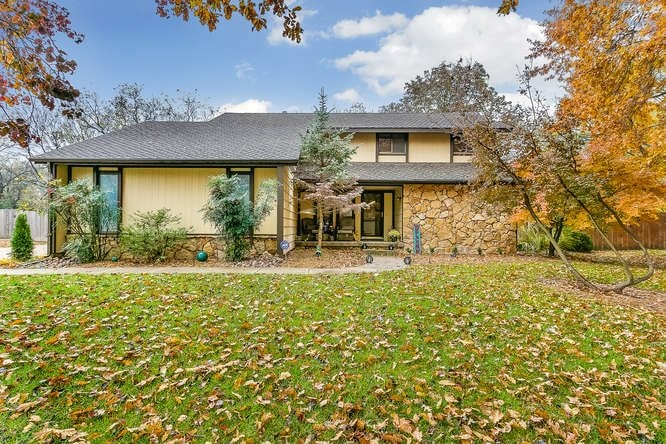 Beautiful home with stone accents and mature trees