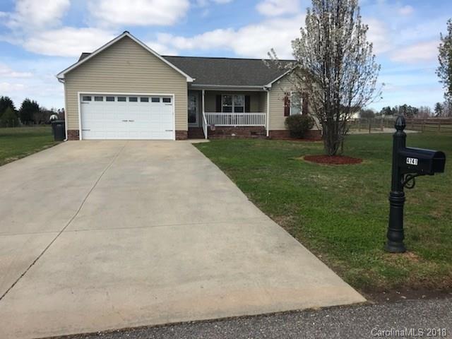 Large concrete driveway, manicured lawn & nice lan