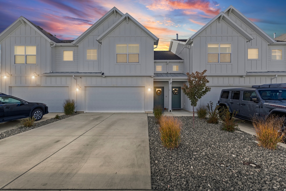 Modern farmhouse with board and batten siding, driveway, a standing seam roof, a metal roof, and an attached garage