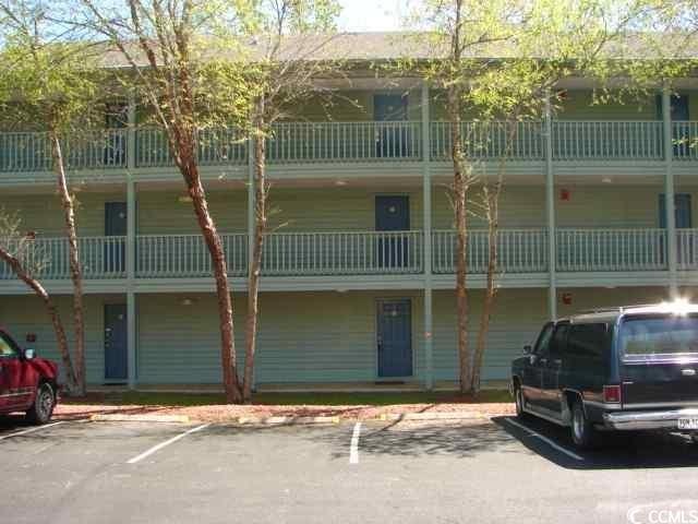 View of building exterior with uncovered parking