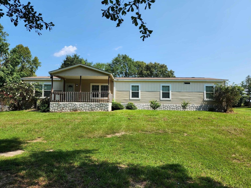 Back of property with a lawn