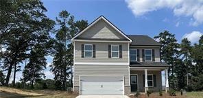 View of front facade with concrete driveway, an attached garage, and covered porch