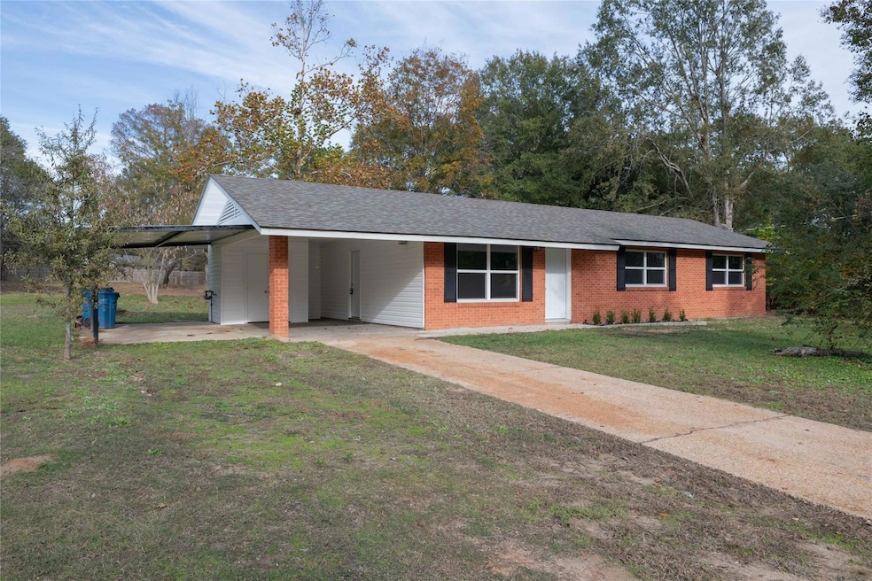 Single story home with a front lawn and a carport