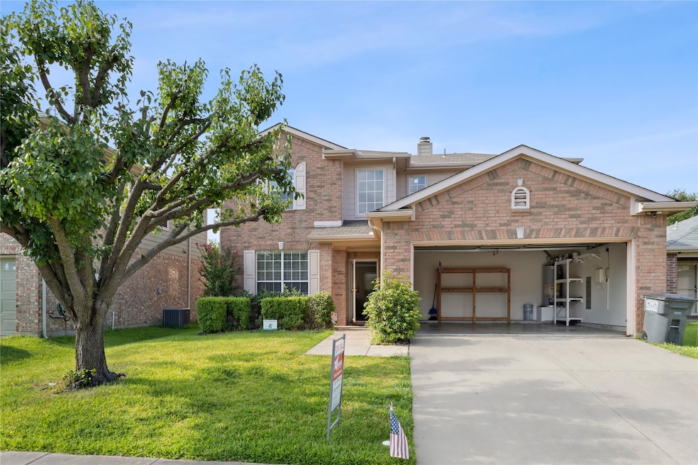 Traditional-style home with concrete driveway, brick siding, a front yard, and a chimney