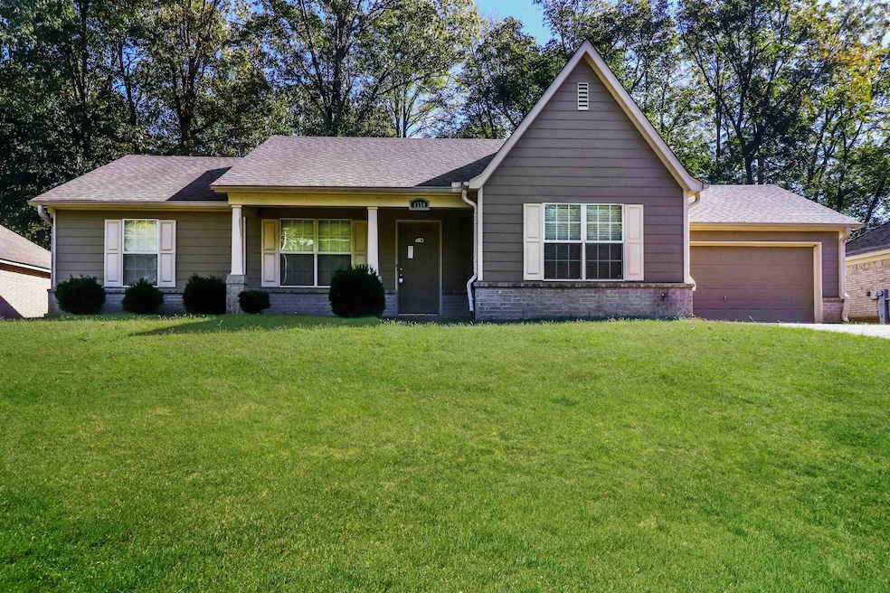 View of front of house with brick siding, a front lawn, a garage, and a shingled roof