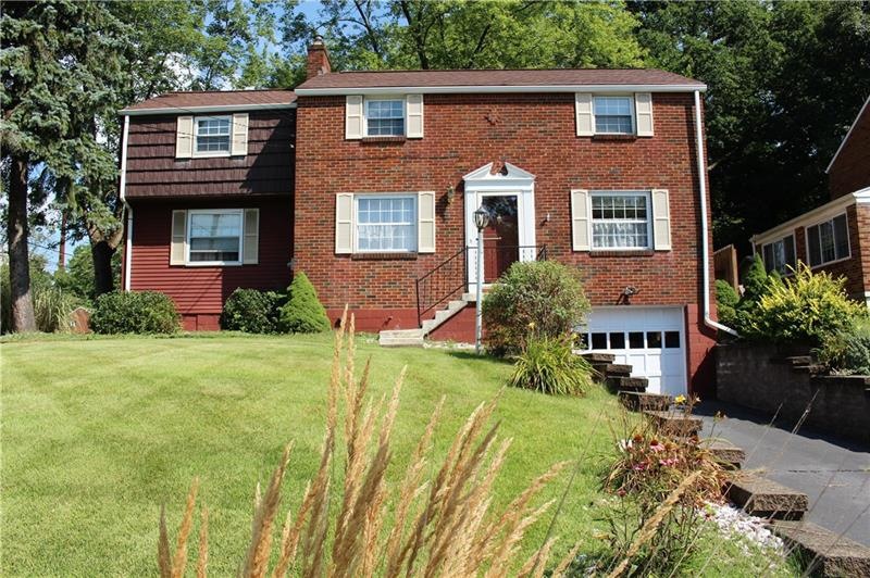 Front of home with extra parking next to driveway.