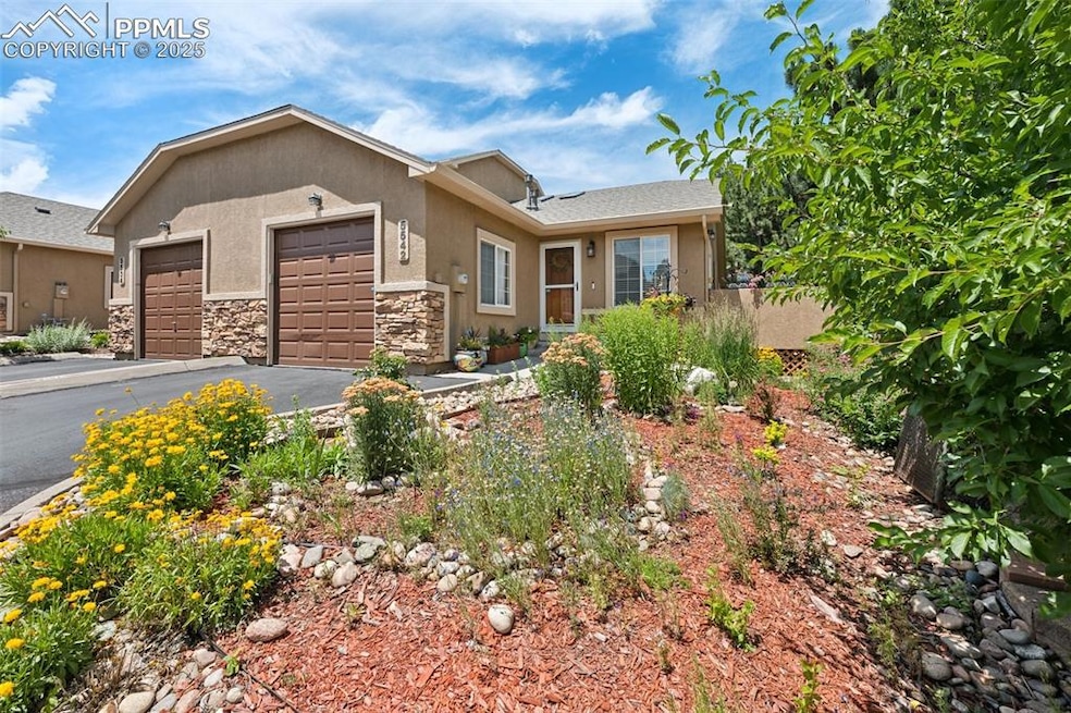 Ranch-style house featuring stucco siding, an attached garage, asphalt driveway, and stone siding