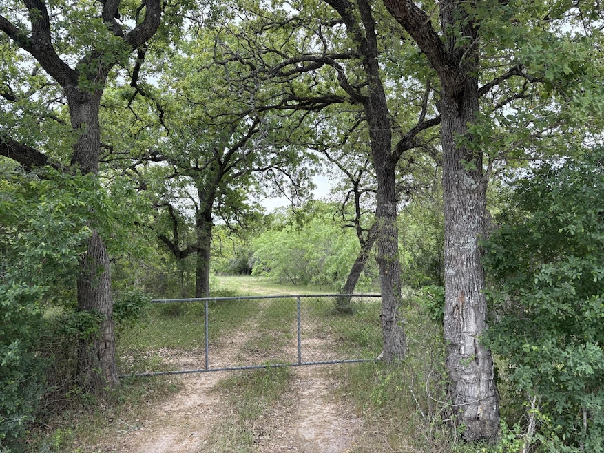 View of yard featuring a wooded view and fence