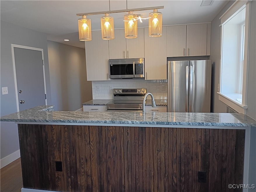 Kitchen featuring backsplash, stone countertops, a