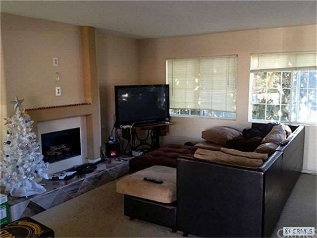 Living Rm with fireplace open to the kitchen.