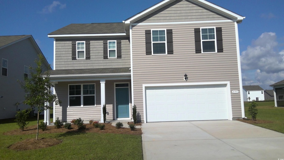 View of front of house with a front yard and a gar