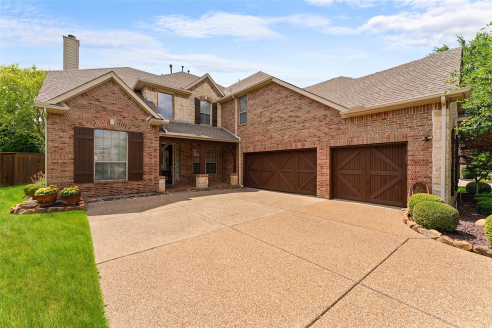 Traditional home with a shingled roof, driveway, brick siding, and a chimney