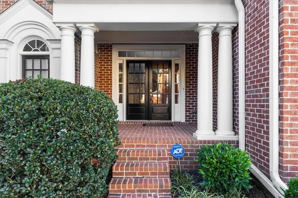 Entrance to property featuring brick siding and covered porch